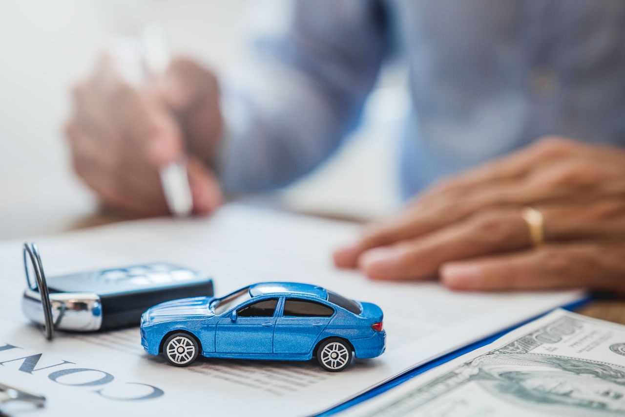 false Sale agent deal to agreement successful car loan contract with customer and sign agreement contract Insurance car concept.
