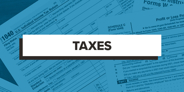 Taxes black letters on faded blue business background
