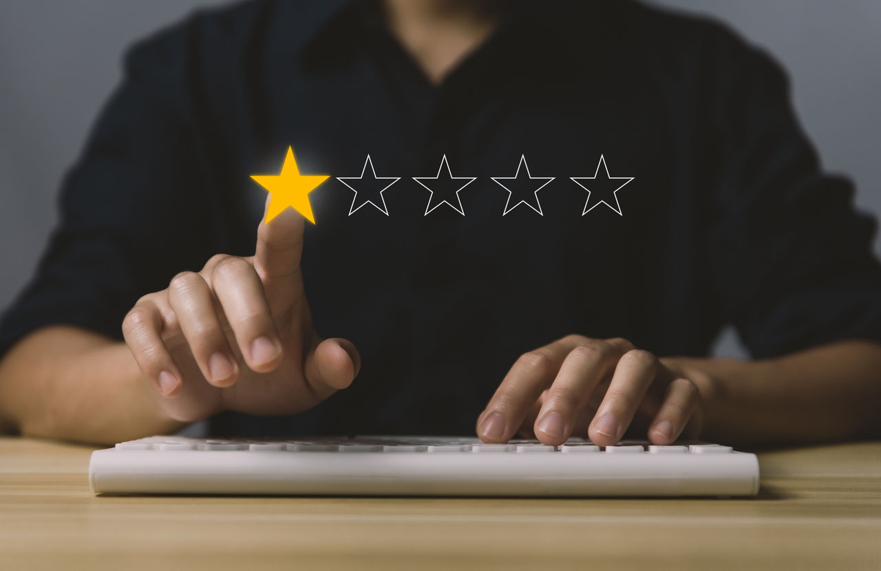 false picture of man on laptop with review stars superimposed across image