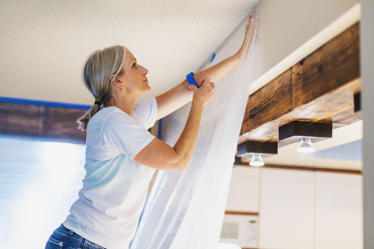 false In Western Colorado Adult Female Using Painter's Tape and Plastic for Painting Preparation; Private Residence Remodel and Updates Photo Series with Matching 4K Video Available (Shot with Canon 5DS 50.6mp photos professionally retouched - Lightroom / Photoshop - original size 5792 x 8688 downsampled as needed for clarity and select focus used for dramatic effect)