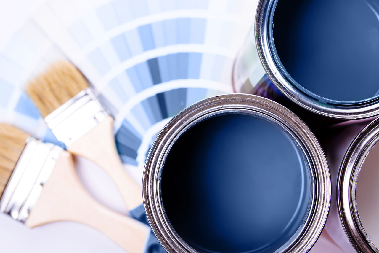 false Paint brushes placed on top of can filled with blue paint. Classic blue color of year 2020