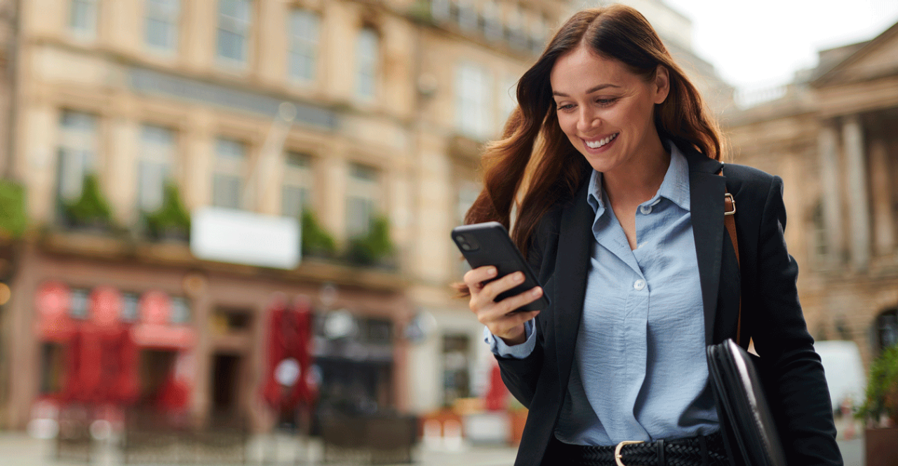 Woman looking at smart phone in city center.